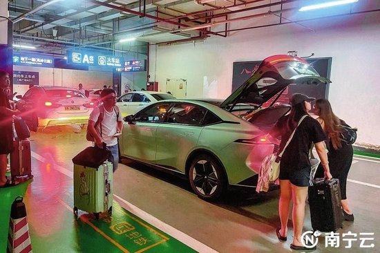 在南宁东站南广场网约车上车点,乘客有序搭乘网约车。(黄维业 摄)