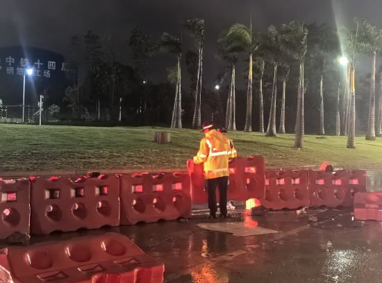 机场交警冒雨恢复隔离水马桩的正常摆放,保障道路畅通