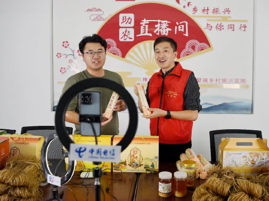 东阳村驻村第一书记朱强(右)和同事在直播带货。 蒋光仕 摄